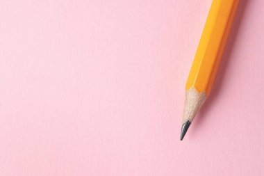 Pembe arka planda keskin bir grafit kalem, üst manzara. Metin için boşluk