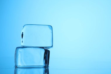 Açık mavi zemin üzerinde açık buz küpleri, yakın plan. Metin için boşluk