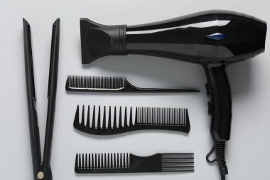 Beyaz arka planda farklı saç şekillendirme araçları, düz yatış