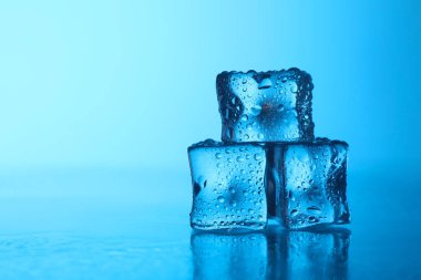 Açık mavi zemin üzerinde açık buz küpleri, yakın plan. Metin için boşluk