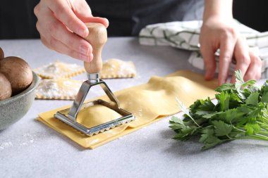 Işık masasında ravioli kesen kadın, yakın plan.