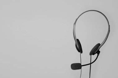 Açık gri arkaplanda mikrofonlu kulaklık, metin için boşluk