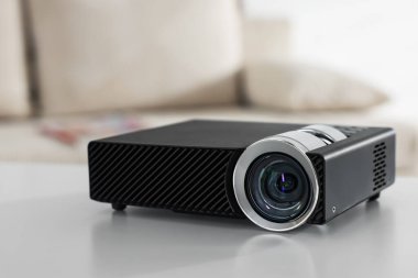 Beyaz masa üzerinde modern video projektörü, yakın plan.