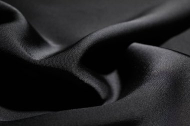 Arkaplan olarak buruşmuş siyah ipek kumaş, yakın plan