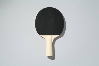 Açık arkaplanda bir ping pong raketi, üst görünümde.