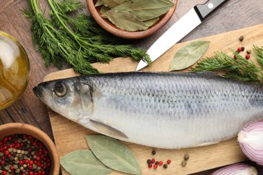 Tuzlu ringa balığı, baharat ve bıçak ahşap masada, düz yerde.