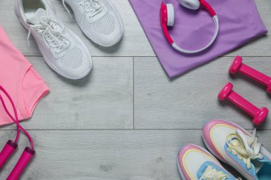 Spor kıyafetleri, spor ayakkabıları, ip atlama, kulaklık ve dambıl, düz yatış. Metin için boşluk