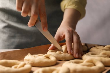 Sofrada pişmemiş kraker kesen kadın, yakın plan.