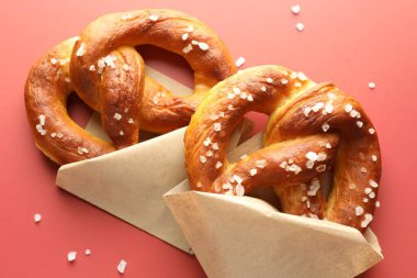 Kırmızı zemin üzerinde tuz bulunan lezzetli krakerler, düz uzanmış.