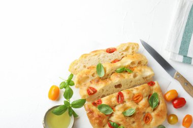 Domates, fesleğen, yağ ve bıçakla nefis Focaccia 'yı ışık masasında düz bir şekilde doğra. Metin için boşluk