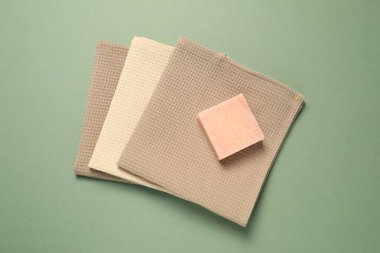 Yeşil arka planda temiz waffle havluları ve sabun kalıbı.