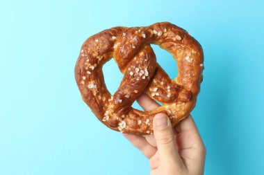 Açık mavi arka planda lezzetli krakerli kadın, yakın plan.