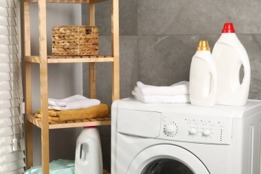 İçerideki çamaşır makinesinde yumuşatıcı ve havlu şişeleri.