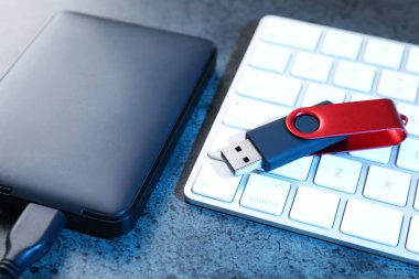 USB flaş bellek, sabit disk sürücü ve klavye koyu gri tabloda, yakın plan
