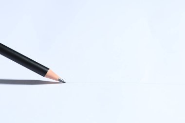 Sharp graphite pencil on white background, closeup. Space for text