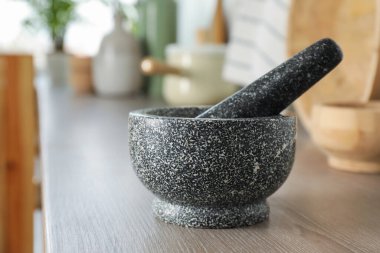 Mutfaktaki ahşap masada taş havan ve tokmak.