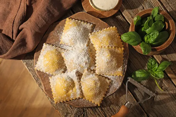 Ahşap masada pişmemiş mantı ve fesleğen.