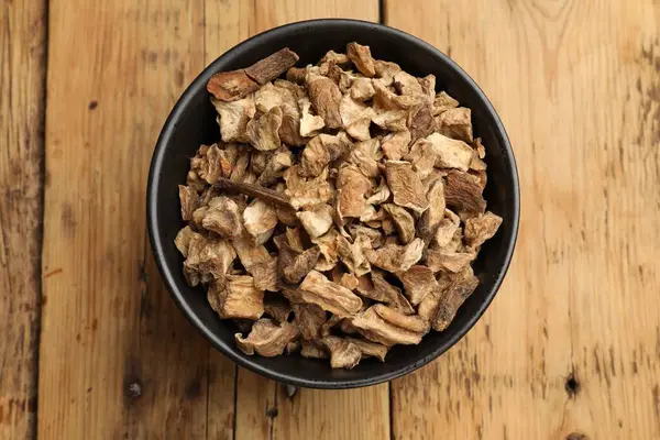 Kuru hindiba kökleri tabakta, ahşap masada, üst tarafta.