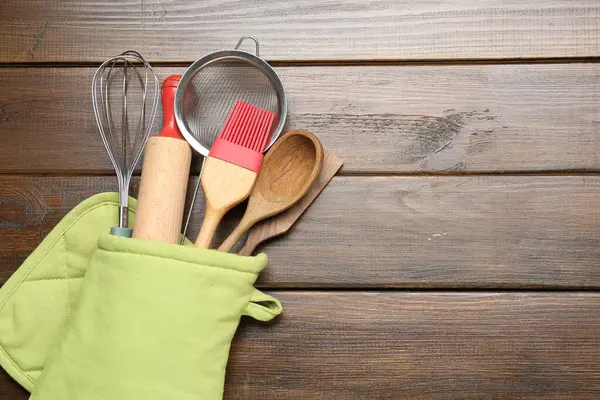 Ahşap masadaki fırın eldiveninde farklı mutfak aletleri, üst manzara. Metin için boşluk