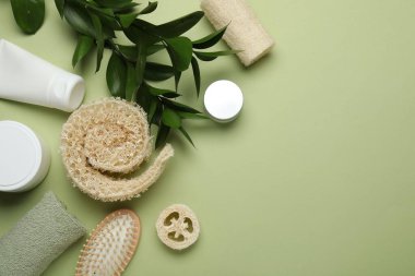 Doğal lif süngeri, kozmetik ürünleri, fırça, havlu ve yeşil arka planda yapraklar, düz yatak. Metin için boşluk