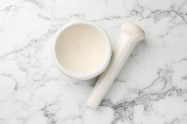 Beyaz mermer masa üzerinde seramik havan ve tokmak, üst görünüm