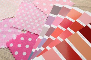 Ahşap masada renkli kumaş örnekleri ve renk paletleri, yakın plan.