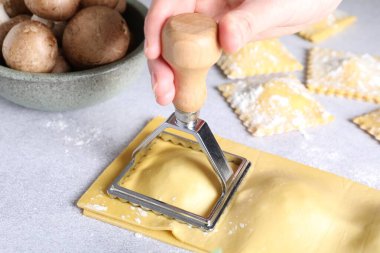 Işık masasında ravioli kesen kadın, yakın plan.