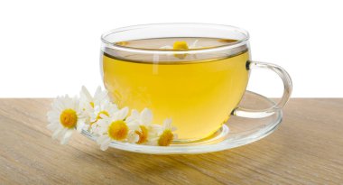 Fincanda nefis papatya çayı ve beyaz arka planda tahta masada taze çiçekler.