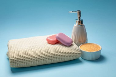 Temiz waffle havlusu, açık mavi arka planda deniz tuzu ve sabun.