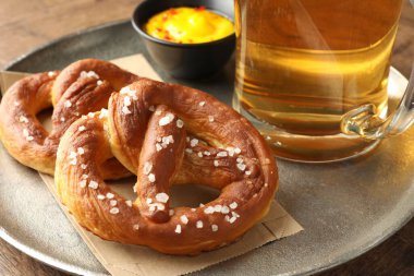 Lezzetli krakerler, sos ve bir bardak bira ahşap masada, yakın plan.