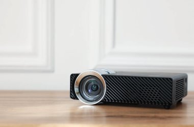 Modern video projektörü ahşap masada, yakın plan. Metin için boşluk