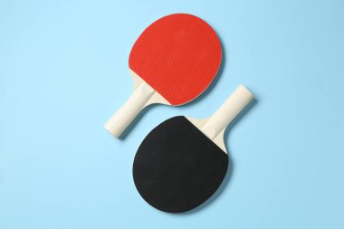 Açık mavi zemin üzerinde pinpon raketleri, düz yatıyordu
