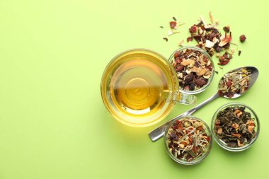 Cam fincanda nefis bitki çayı ve açık yeşil arka planda kuru yapraklar. Metin için boşluk