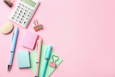 Kalemler ve pembe arka plandaki diğer kırtasiyeler, düz. Metin için boşluk