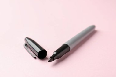 Açık pembe arka planda bir siyah işaret, yakın plan. Metin için boşluk