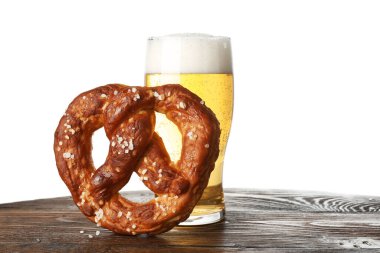 Lezzetli kraker ve bir bardak bira beyaz arka plana karşı ahşap masada.