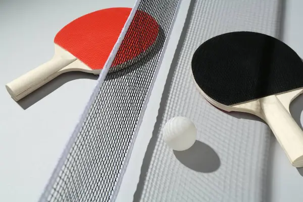 Ping pong raketleri, arka planda top ve ağ