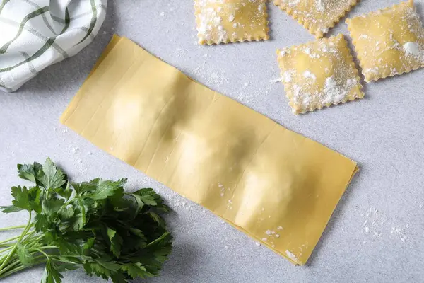 Pişmemiş ravioli ve maydanoz Işık masasında, düz yatıyordu