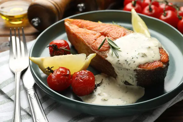 Deniz ürünleri. Sos, domates, biberiye ve limonla servis edilen lezzetli somon bifteği.