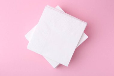 Pembe arka planda beyaz mendil yığını, üst görünüm