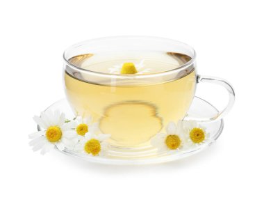 Cam bardakta nefis papatya çayı ve beyaz bardakta taze çiçekler.