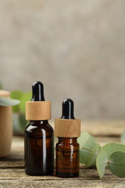 Kaliteli yağ ve okaliptüs yaprakları ahşap masada, yakın plan.