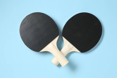 Açık mavi zemin üzerinde pinpon raketleri, düz yatıyordu