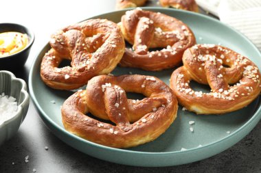 Gri masadaki tuzlu ve soslu krakerler, yakın plan.