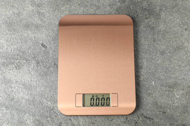 Gri masadaki modern elektronik mutfak ölçeği, üst manzara.