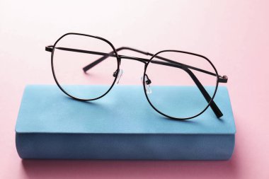 Pembe arka planda şık gözlüklü çanta, yakın plan.