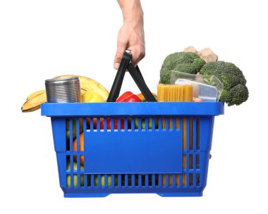 Beyaz arka planda farklı ürünleri olan alışveriş sepeti tutan adam, yakın plan.