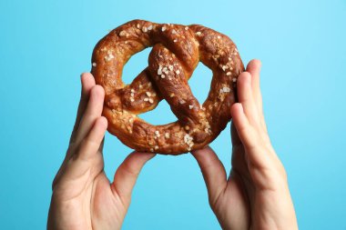 Açık mavi arka planda lezzetli krakerli kadın, yakın plan.