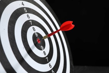 Hedef alınıyor. Siyah arkaplanda ok olan dart tahtası, yakın plan