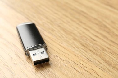 Tahta arka planda bir flaş bellek, yakın plan. Metin için boşluk